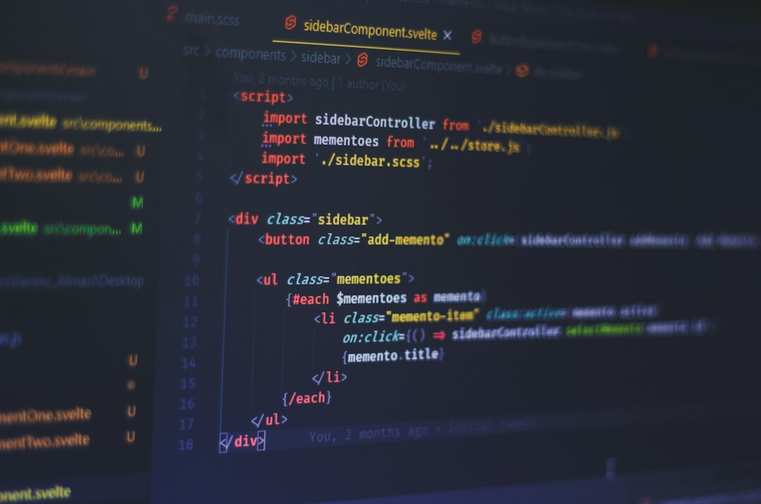 person coding on laptop